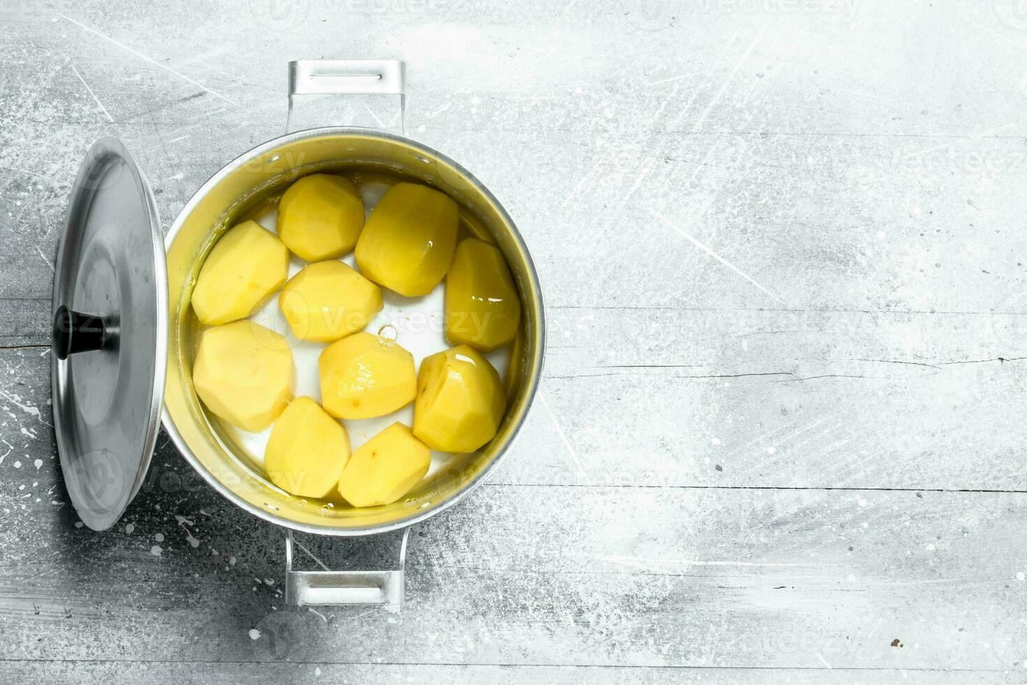 Peeled potatoes in a pot. photo