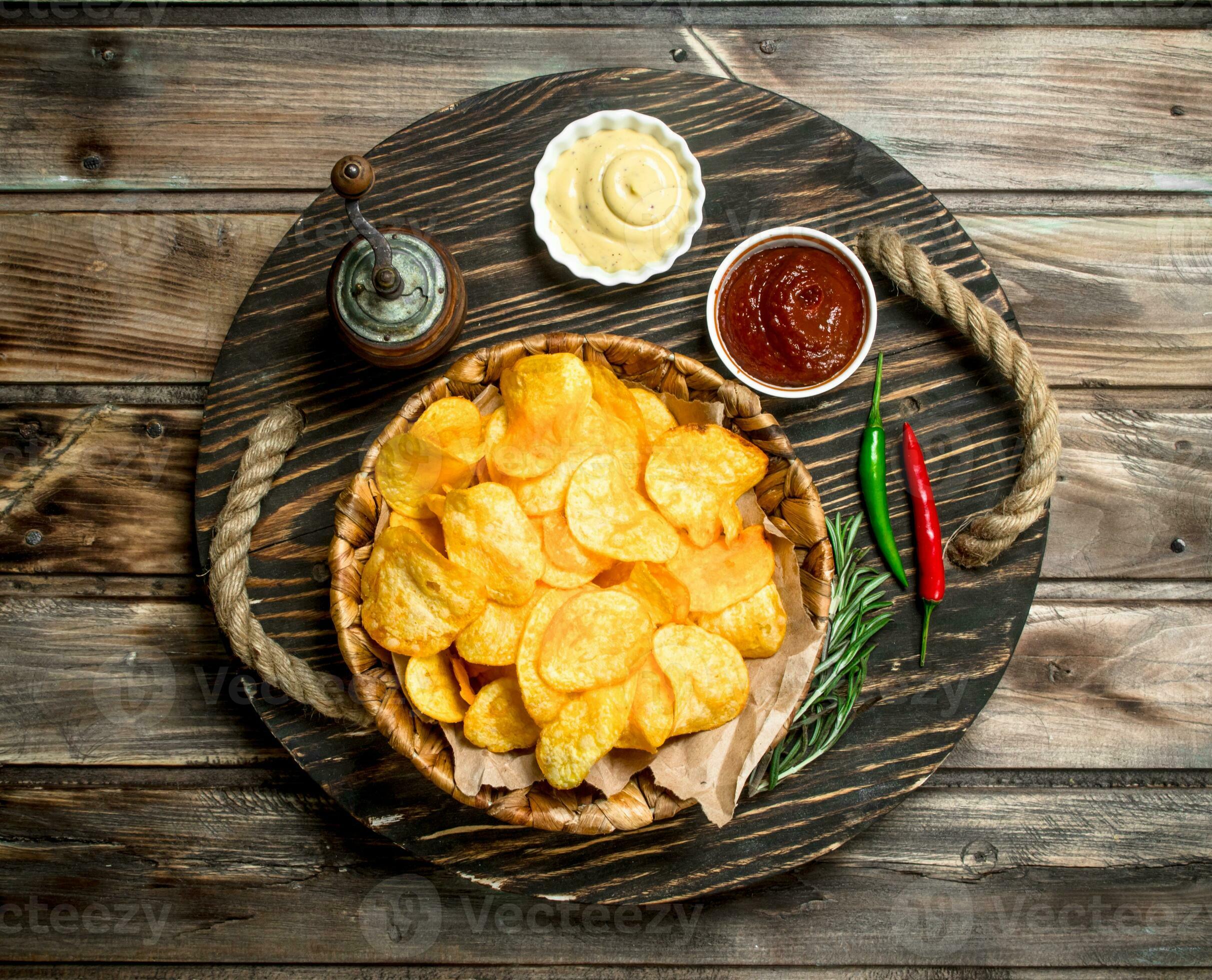 Potato chips in a basket with different sauces. 32009023 Stock Photo at