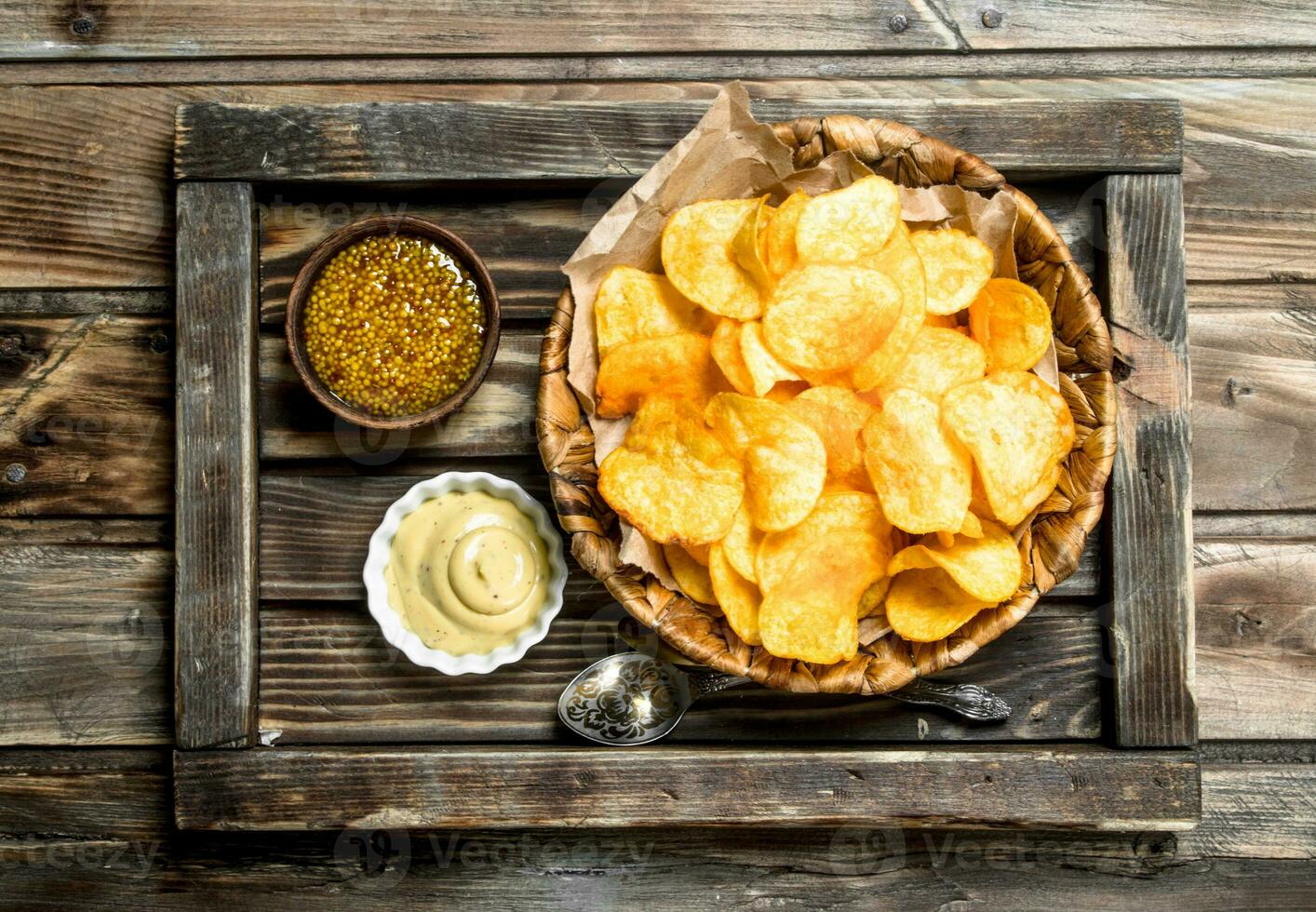Potato chips in a basket with different sauces. 32009035 Stock Photo at