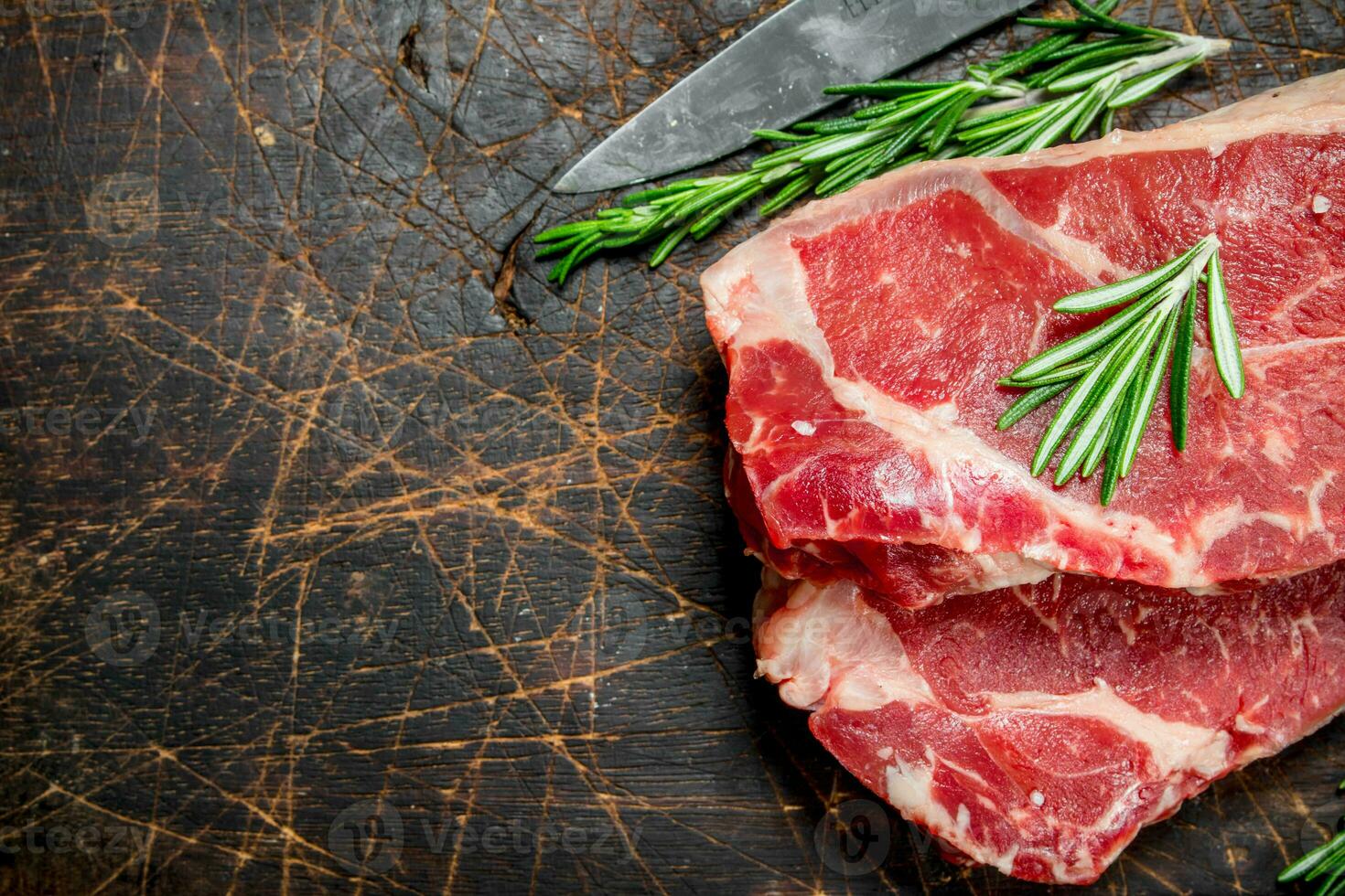 Raw marbled beef steaks with rosemary. photo