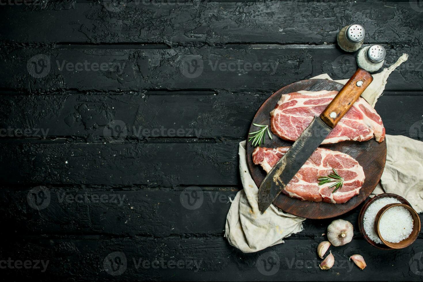 Raw pork steak with an old knife on a cutting Board. photo