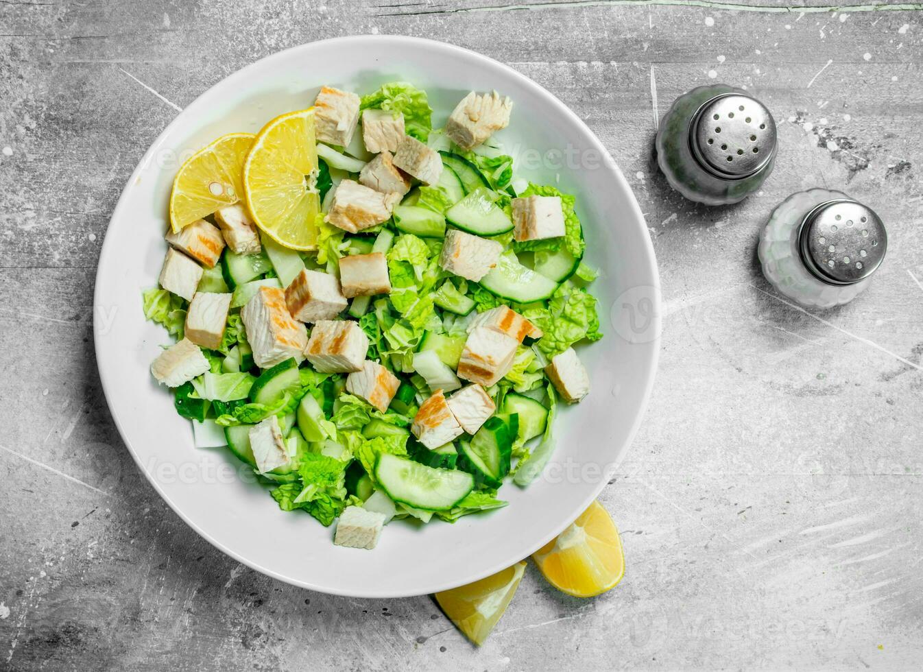 Healthy salad. Salad with cucumbers, chicken and Chinese cabbage poured lemon juice . photo