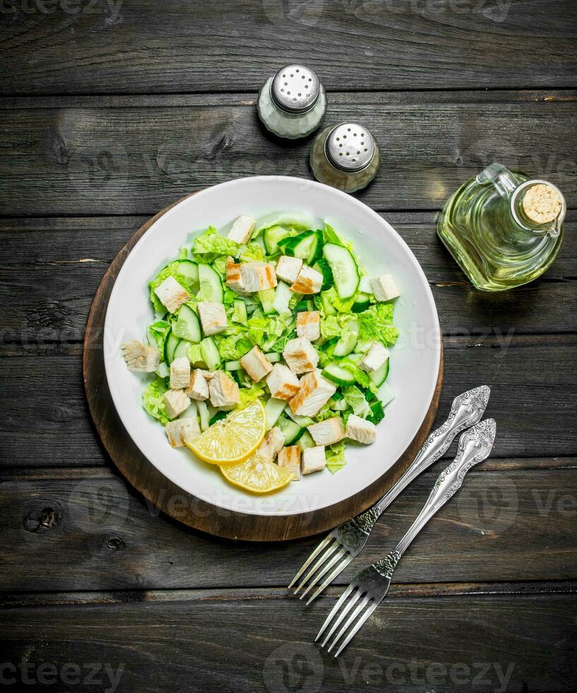Healthy salad. Salad with cucumbers, chicken and Chinese cabbage poured lemon juice . photo
