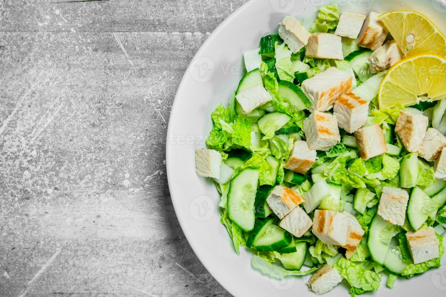 Healthy salad. Salad with cucumbers, chicken and Chinese cabbage poured lemon juice . photo