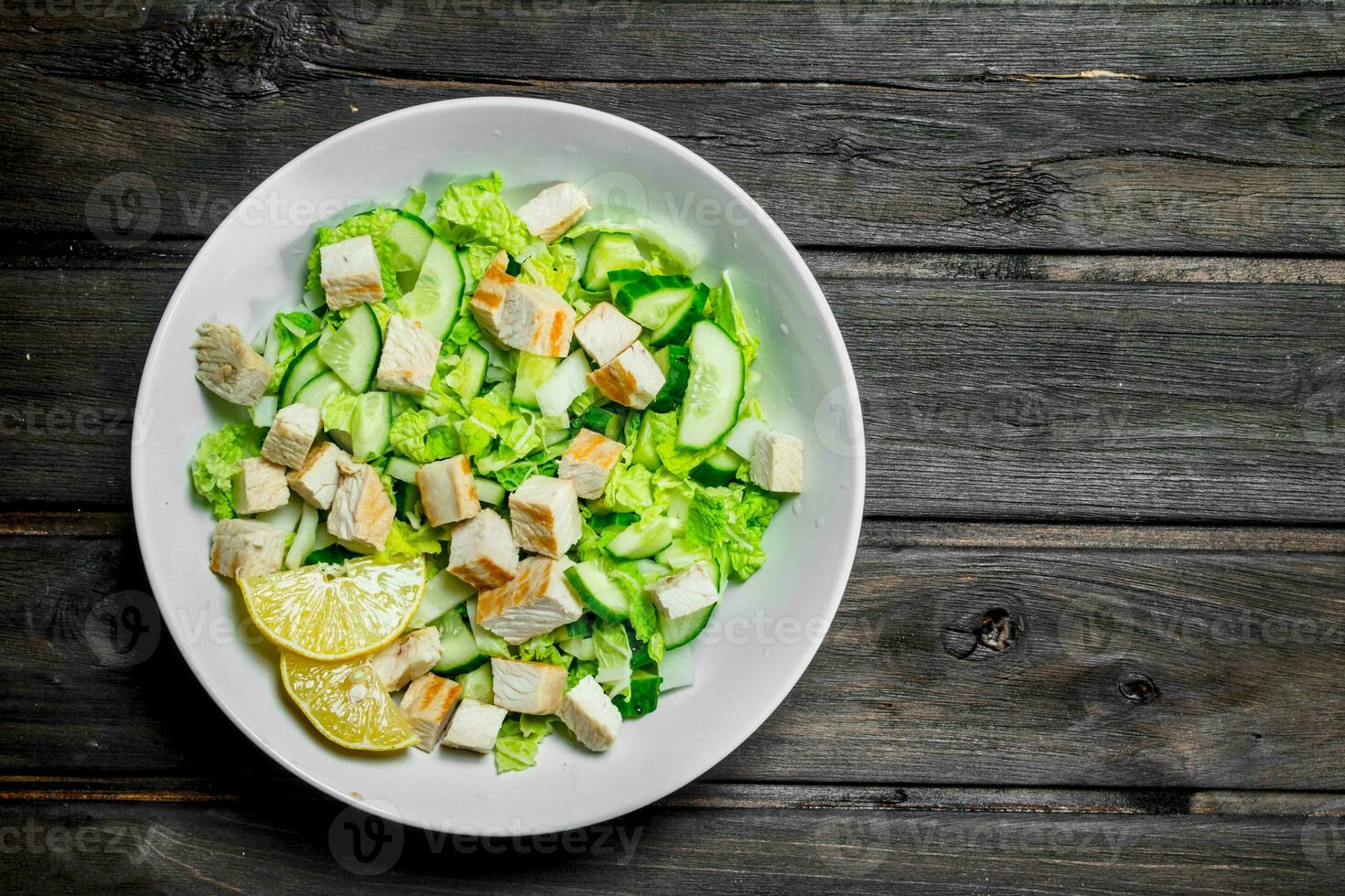 Healthy salad. Salad with cucumbers, chicken and Chinese cabbage poured lemon juice . photo