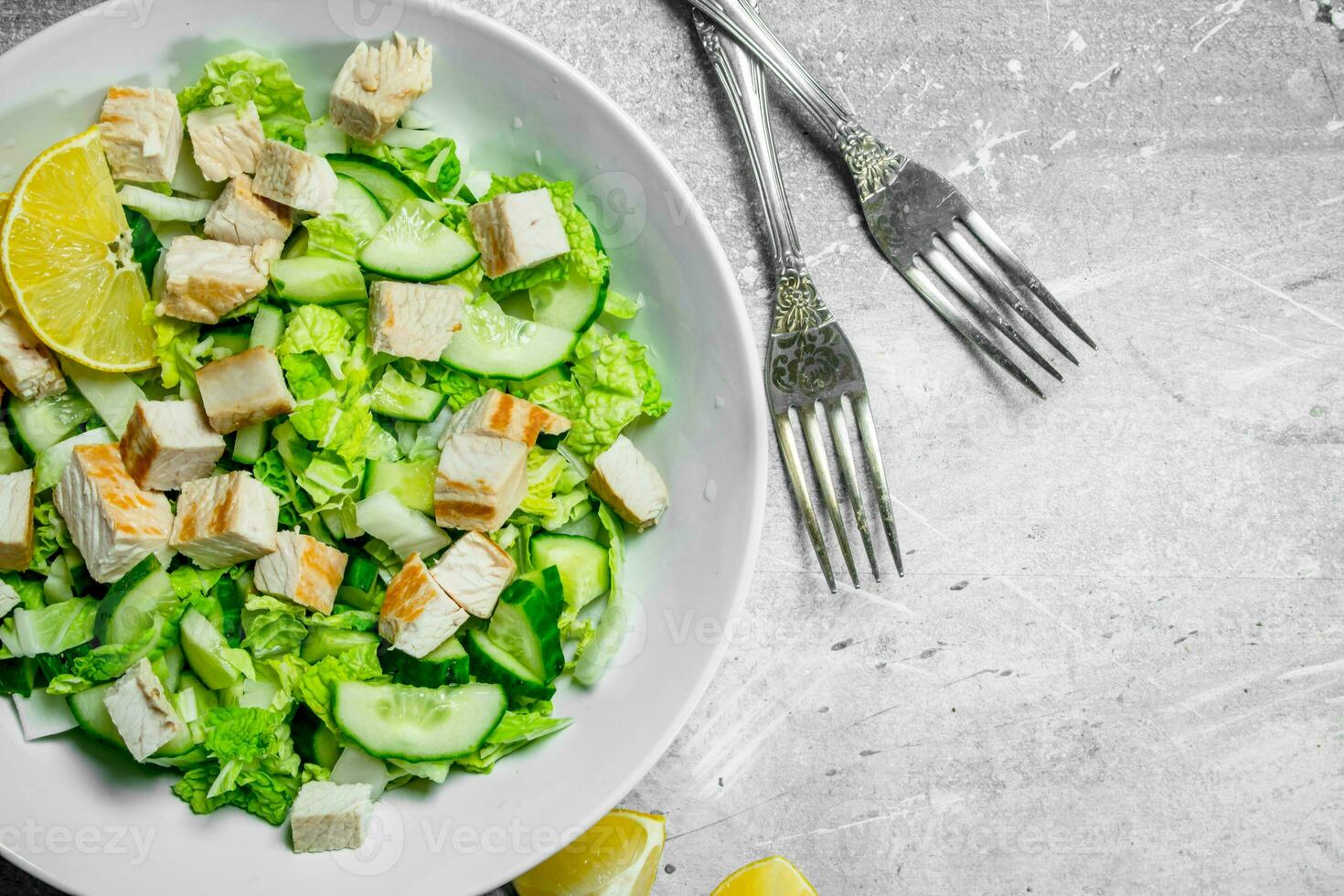 Healthy salad. Salad with cucumbers, chicken and Chinese cabbage poured lemon juice . photo
