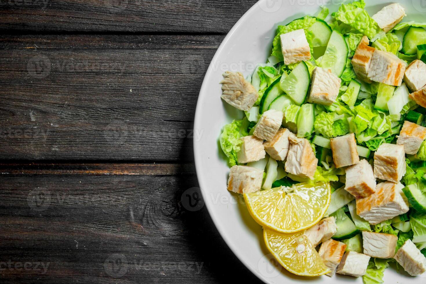 Healthy salad. Salad with cucumbers, chicken and Chinese cabbage poured lemon juice . photo