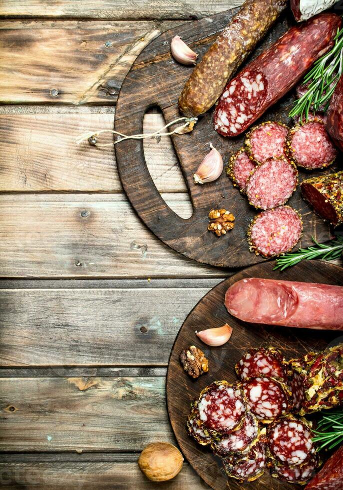 Various types of salami on a Board with nuts. photo
