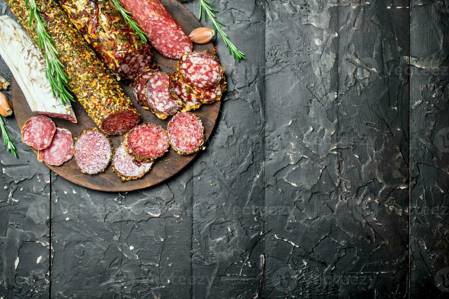 Assortment of different salami with spices and herbs. photo