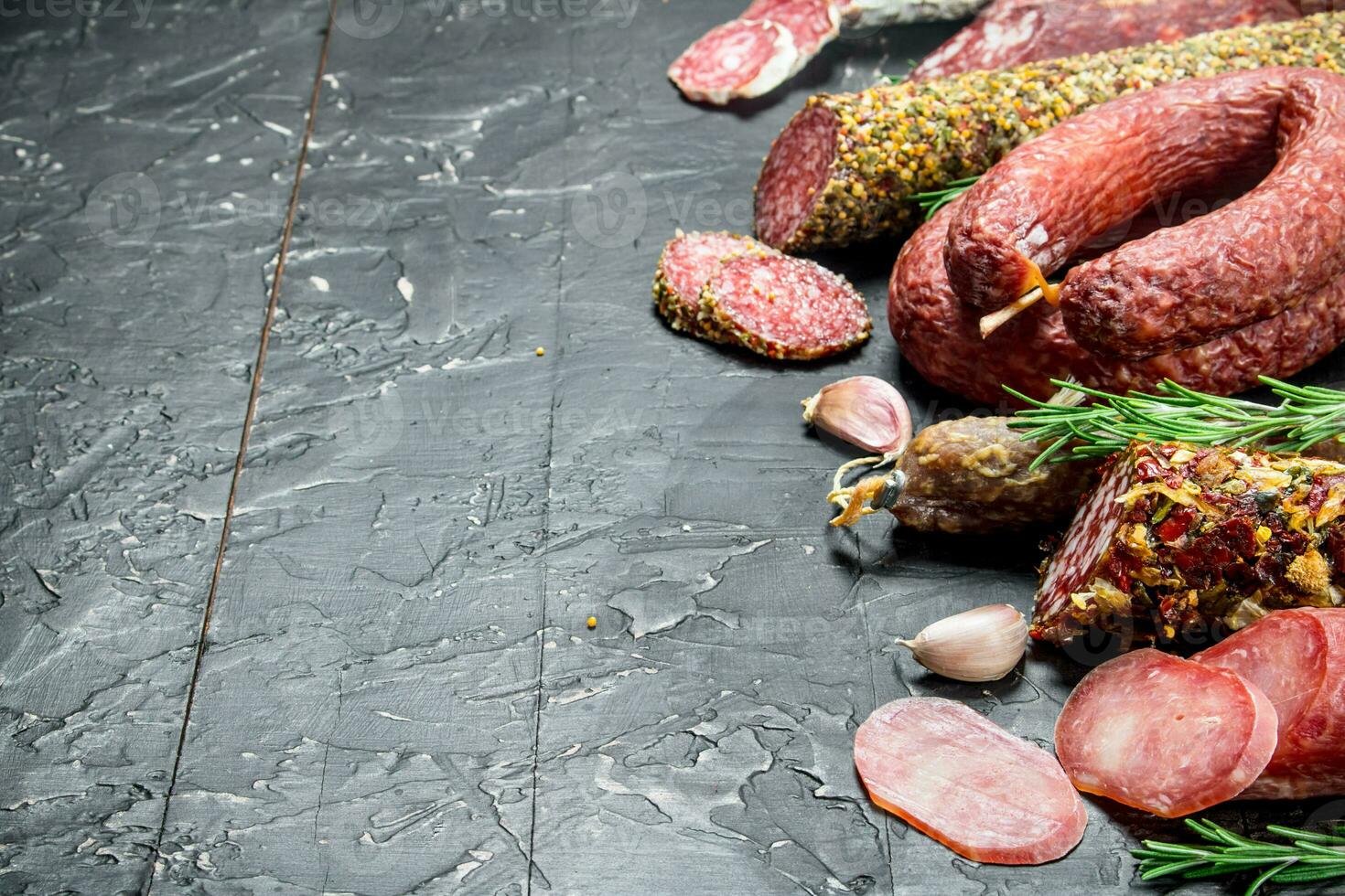Assortment of different salami with spices and herbs. photo