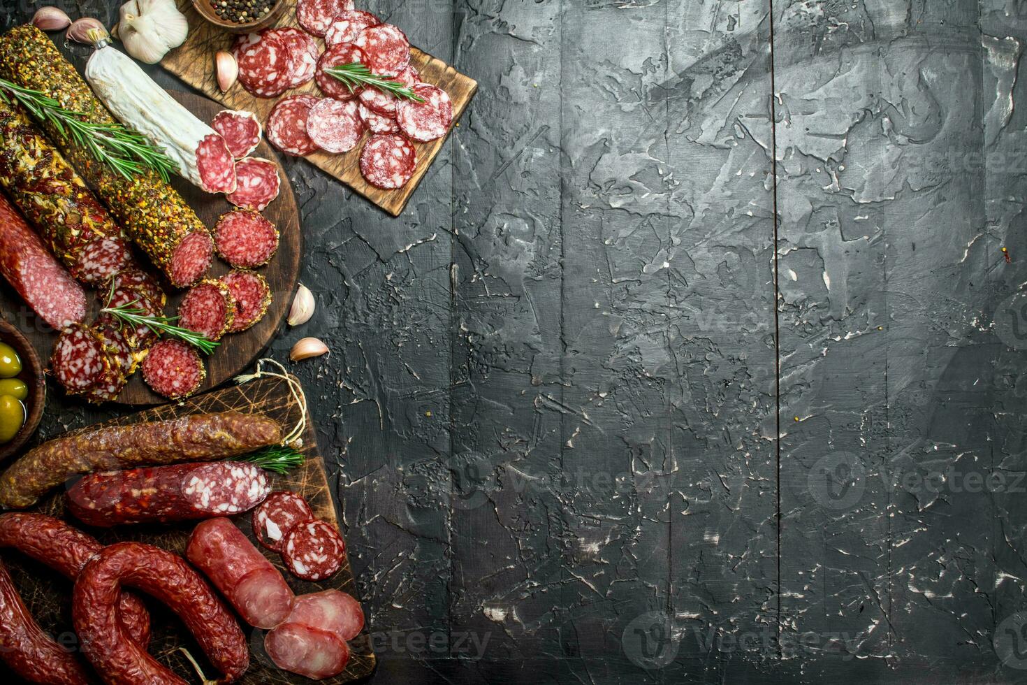 Assortment of different salami with spices and herbs. photo