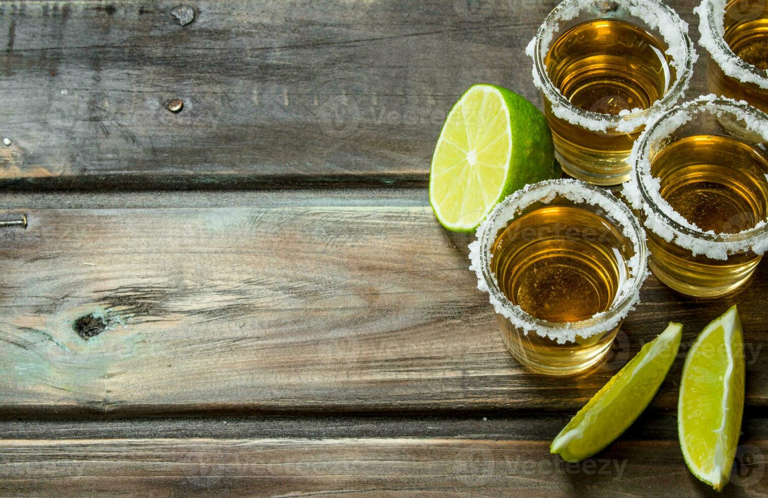 Tequila in a shot glass with lime slices. photo