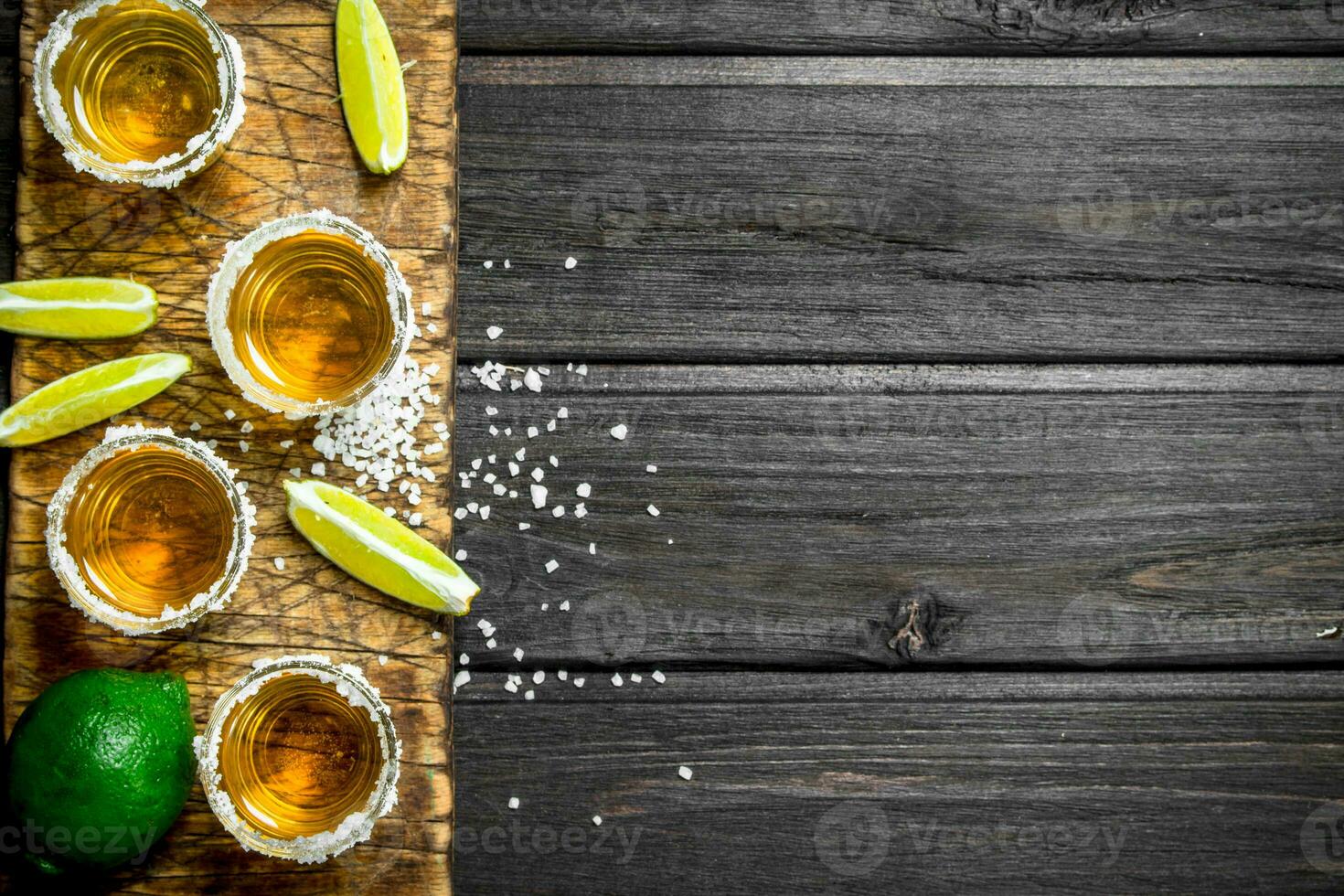 Tequila on a cutting Board with slices of fresh lime. photo