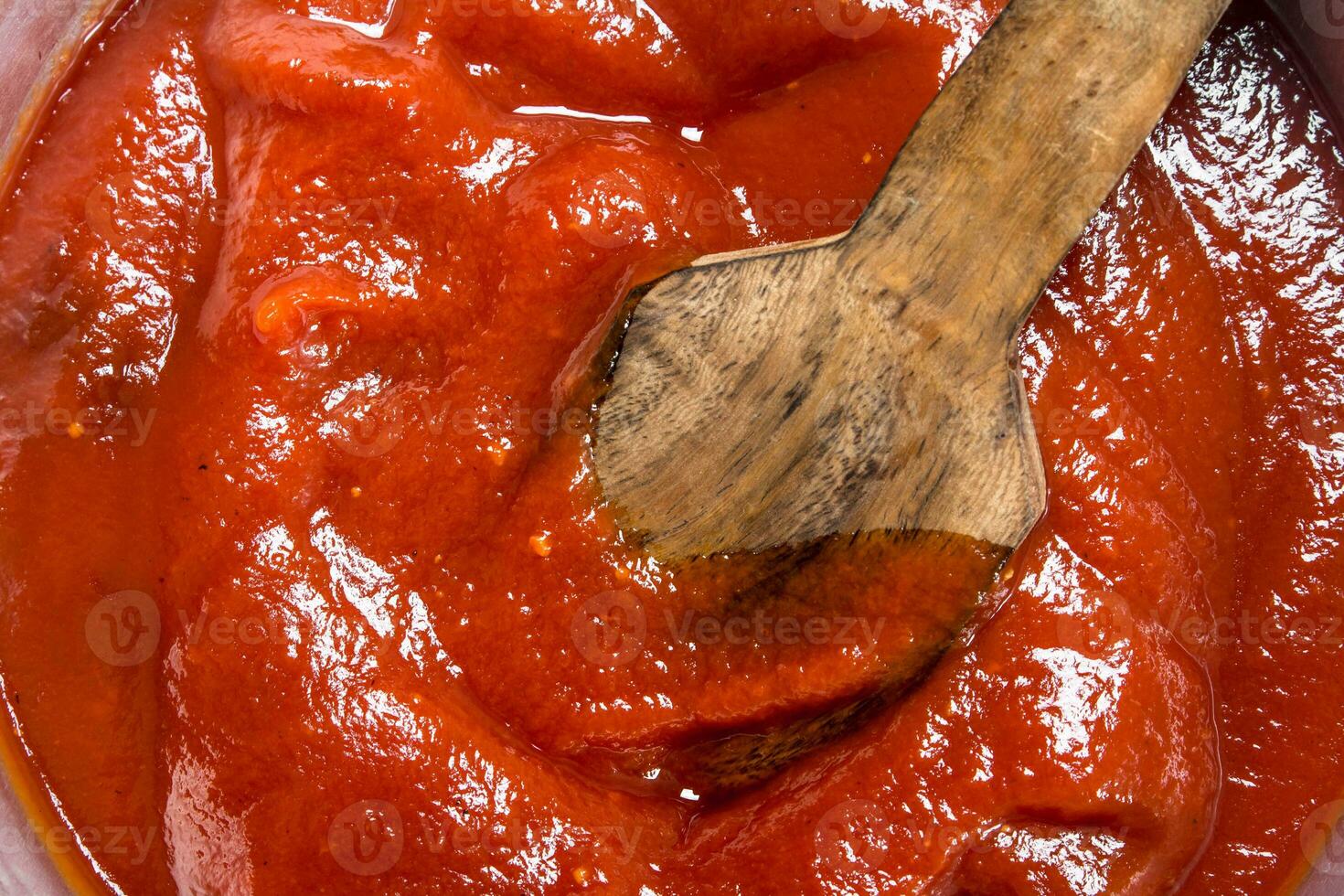 Tomato sauce with a wooden scoop. photo