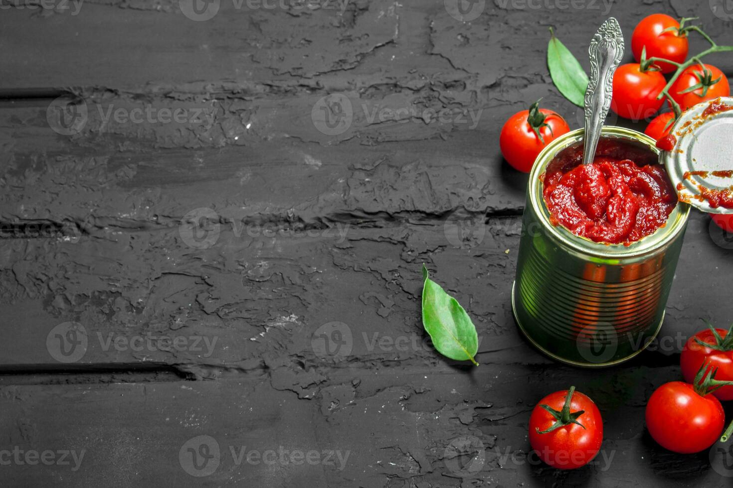 Tomato sauce in a tin can with a spoon. photo