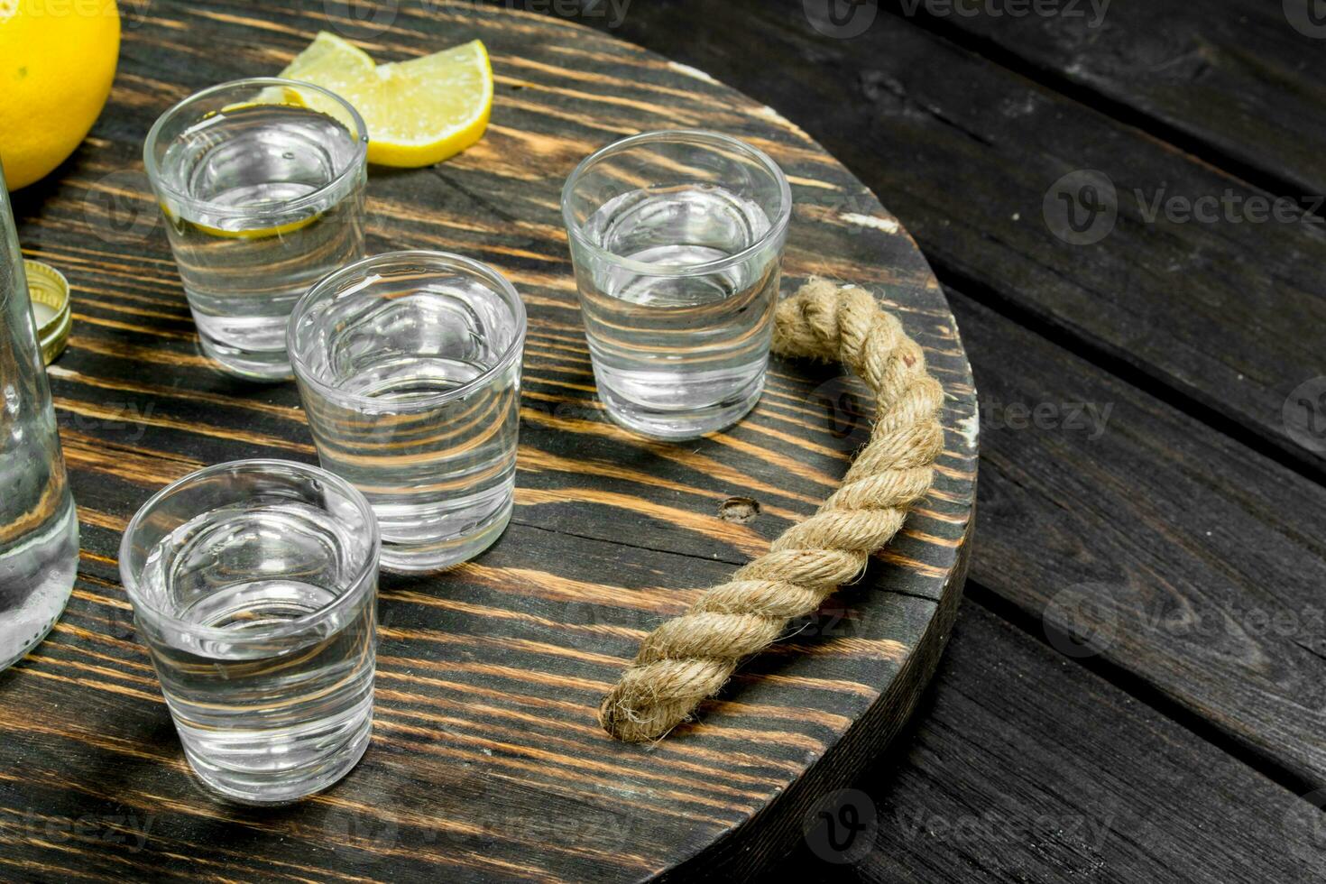 Vodka on a tray with lemon. photo