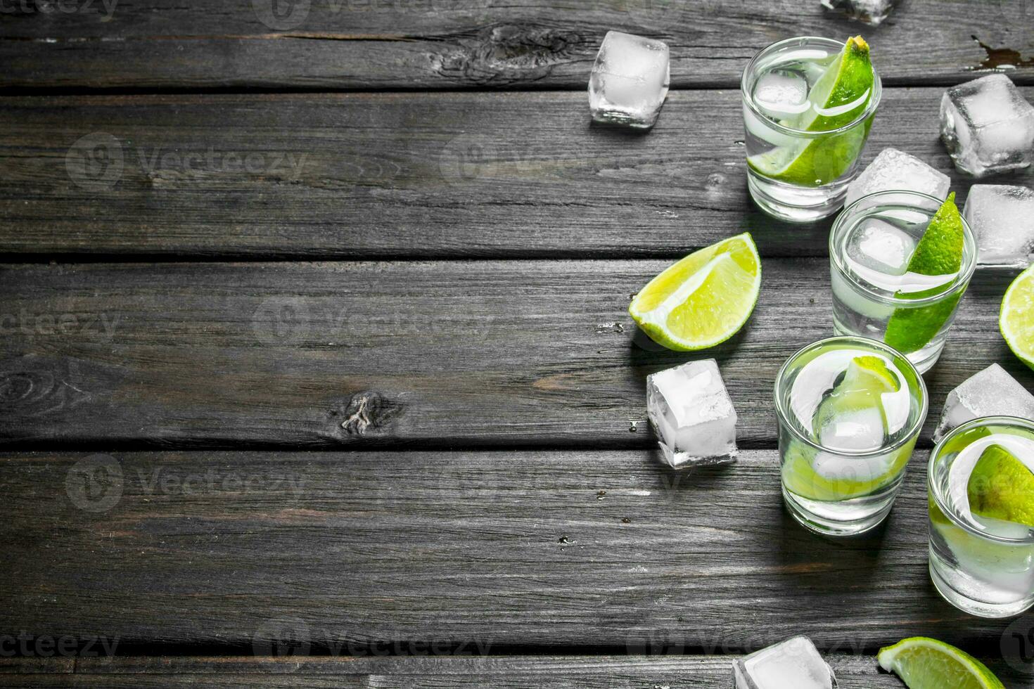 Vodka in a shot glass of lime and ice. photo