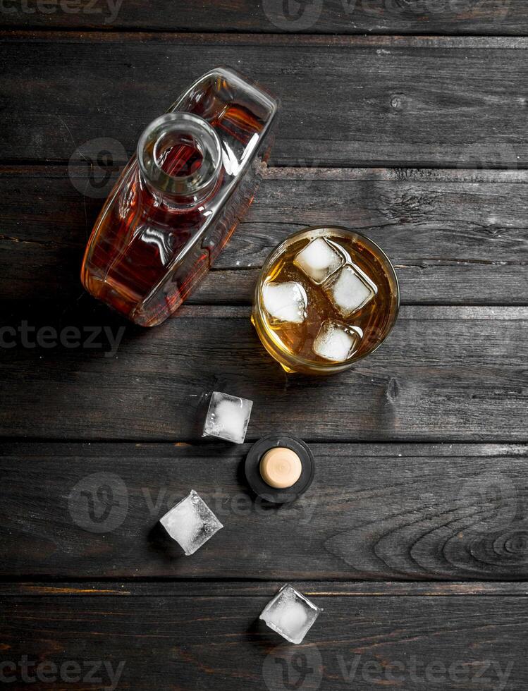 Whiskey in a bottle with ice cubes. photo