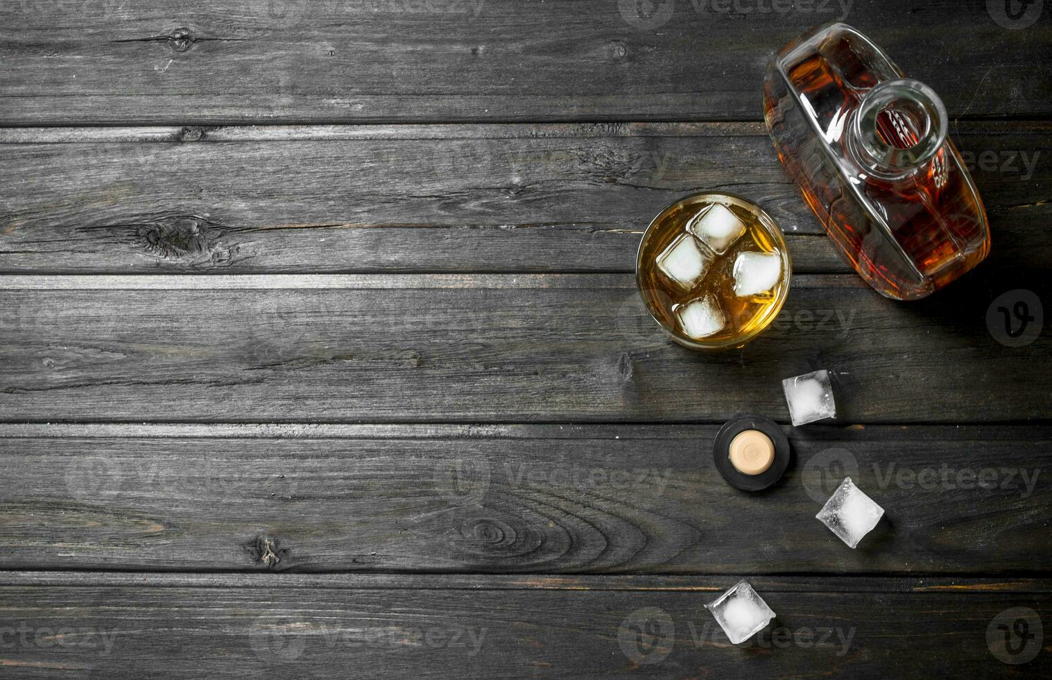 Whiskey in a bottle with ice cubes. photo