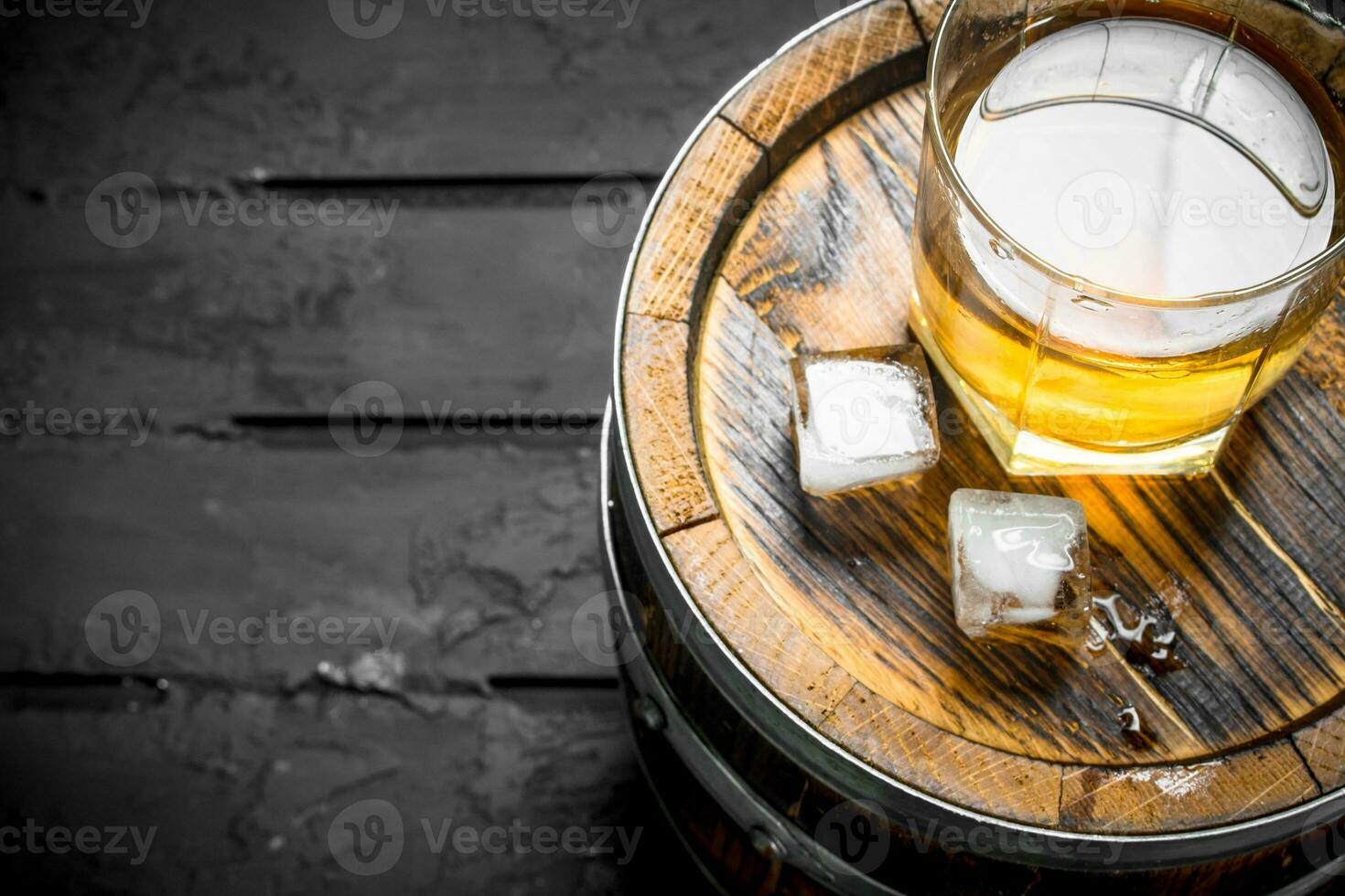 Whiskey in a glass on a barrel. photo