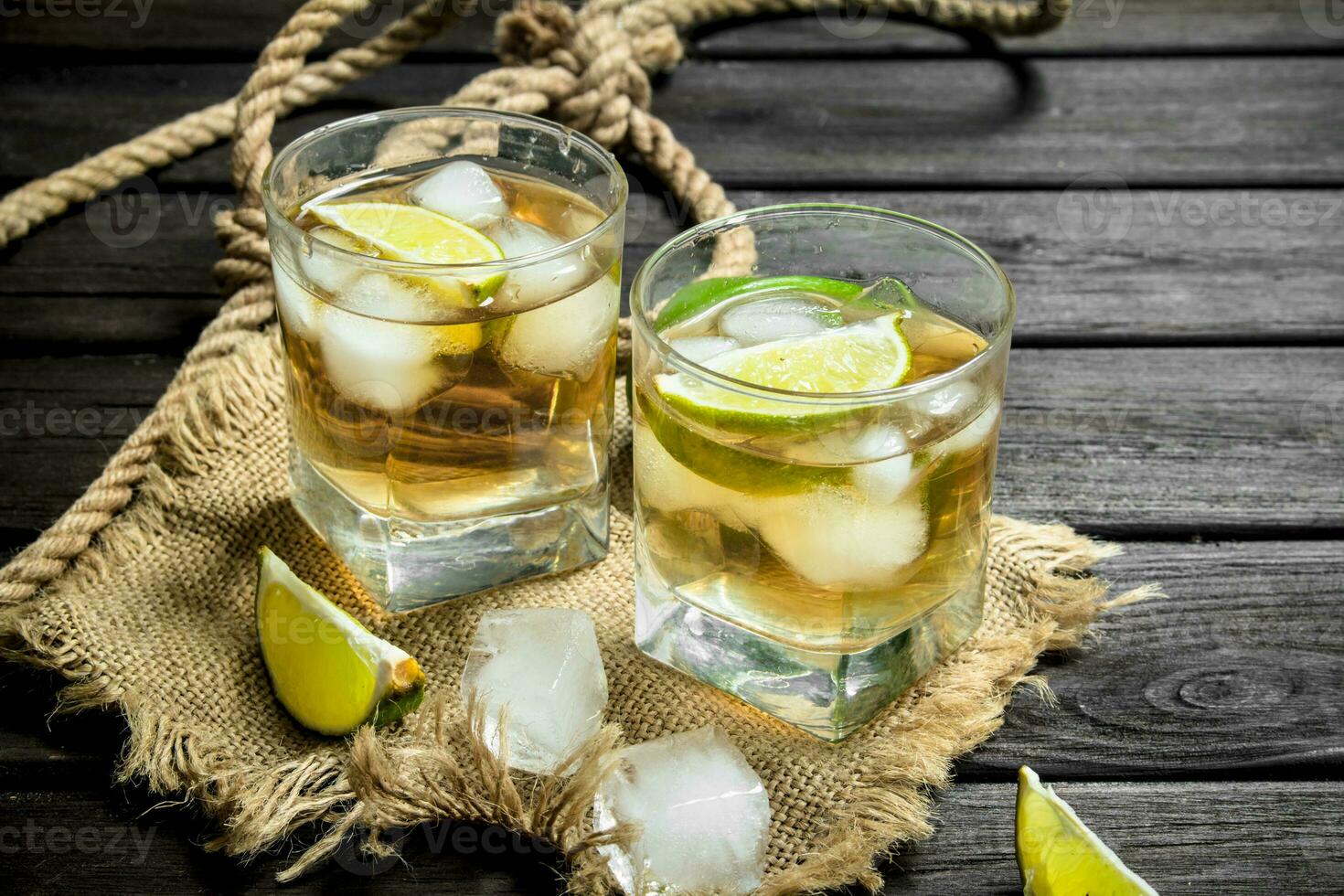 Whiskey in a glass with lime and ice on the sack. photo