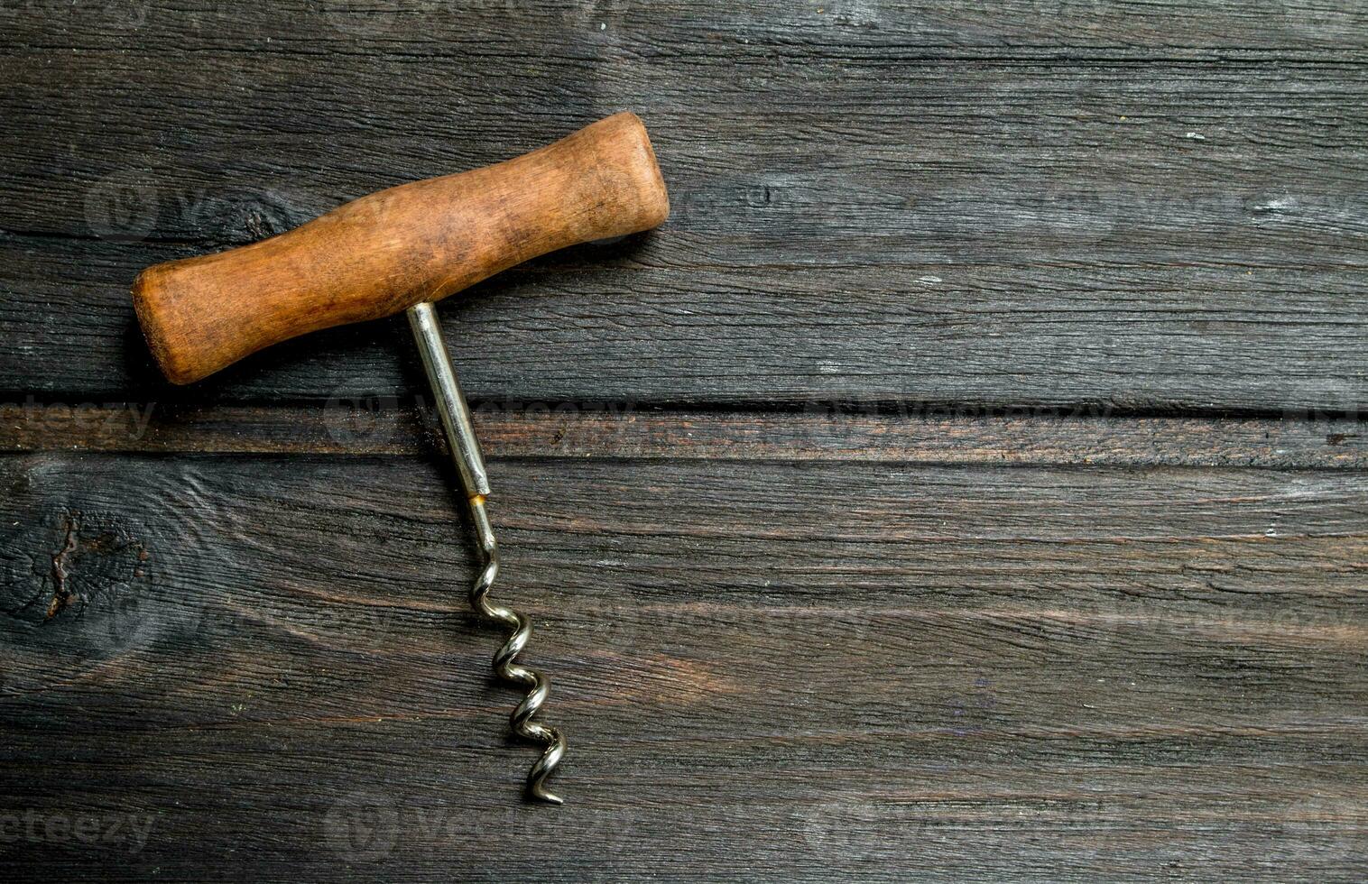 Wine corkscrew on wooden background. photo