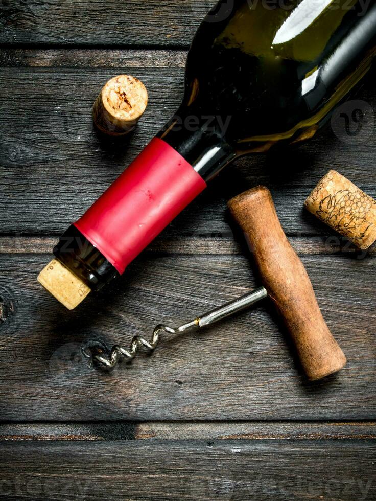 bottle of red wine with a corkscrew. photo