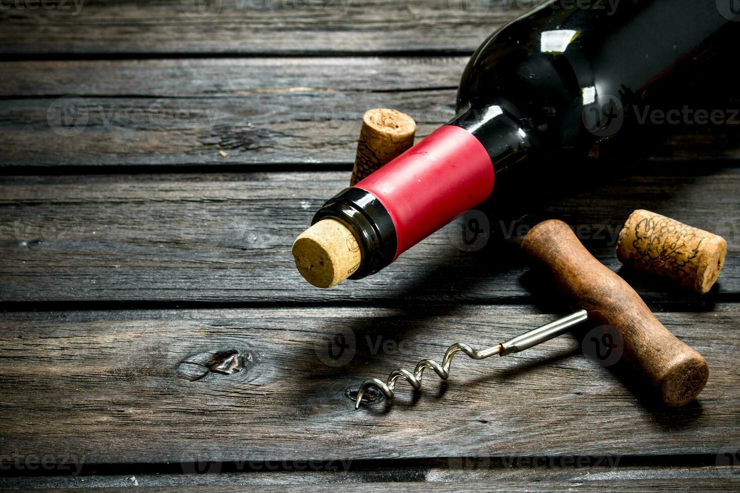 bottle of red wine with a corkscrew. photo