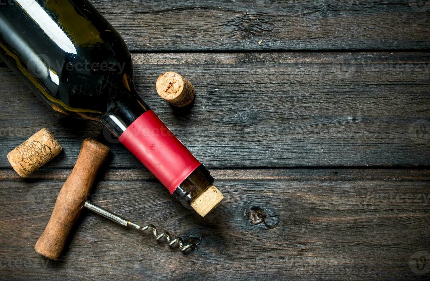 bottle of red wine with a corkscrew. photo