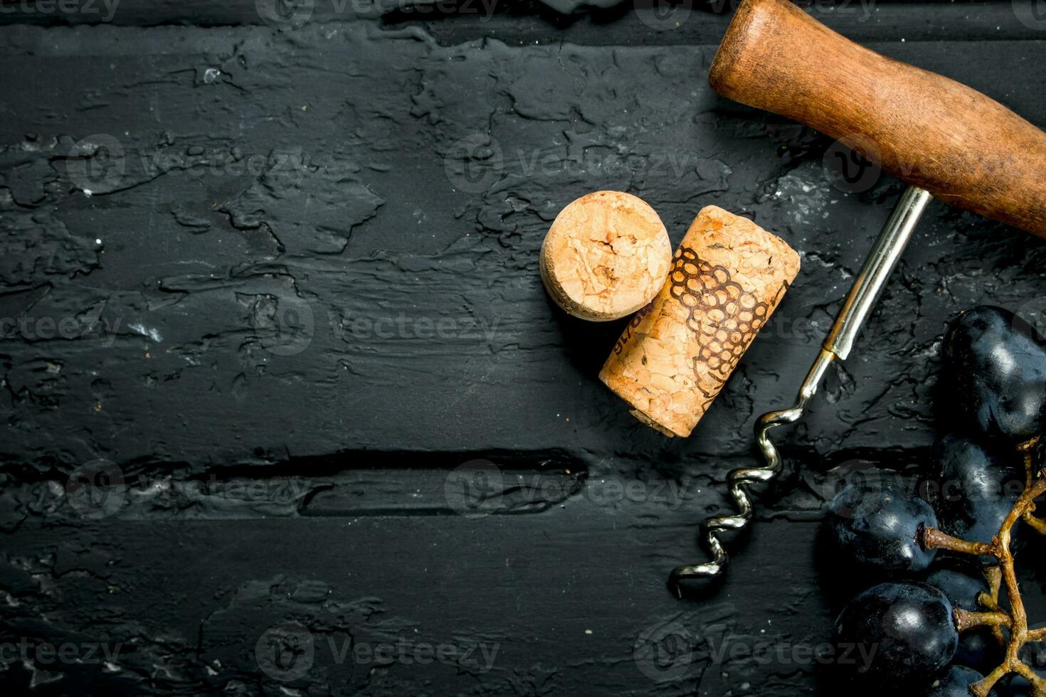 Wine background. Corkscrew with a branch of grapes and corks. photo