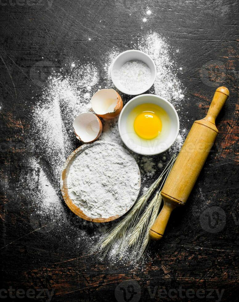 Flour with egg and a rolling pin. photo