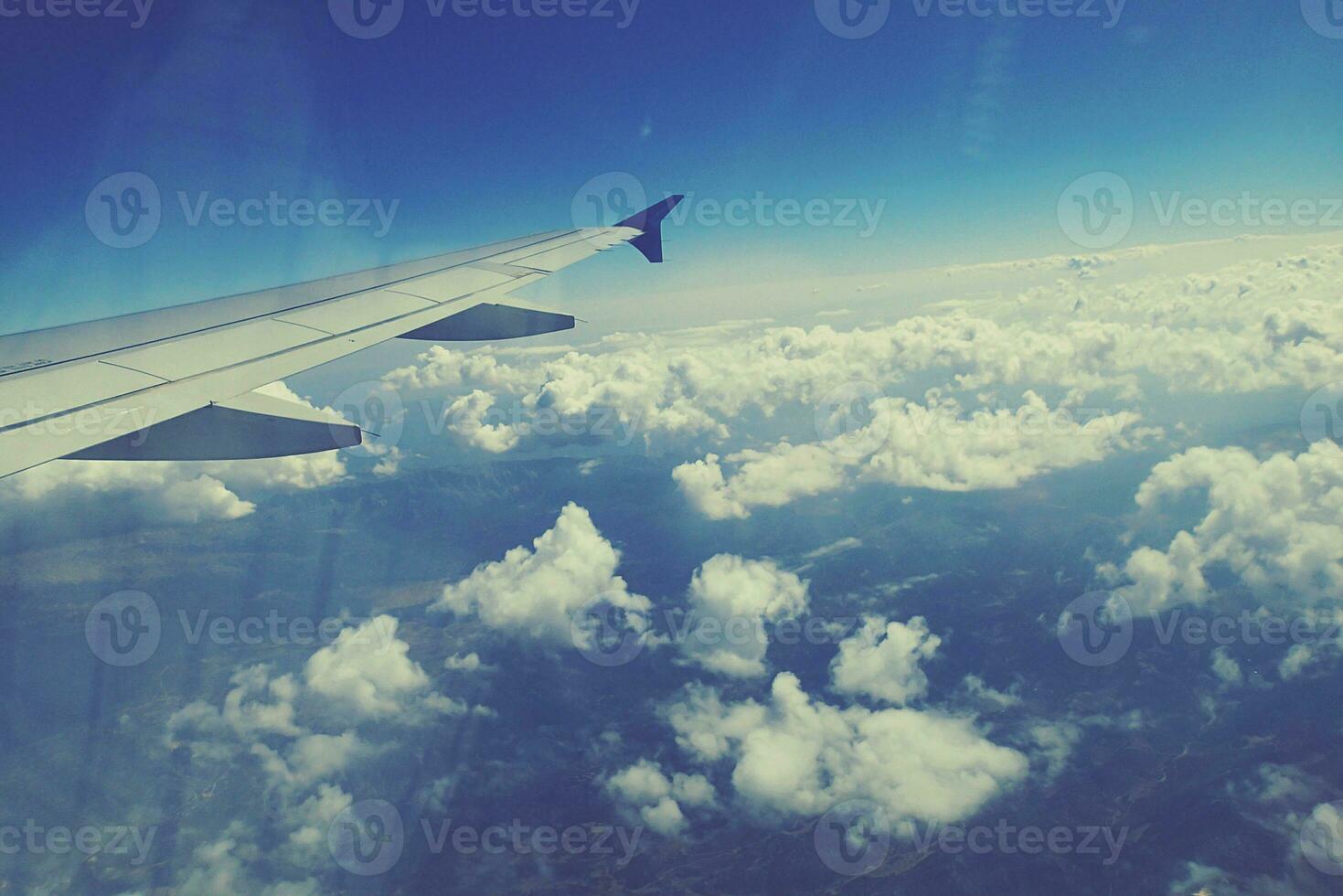 white clouds against the blue sky seen from the flight from the windows of the plane photo