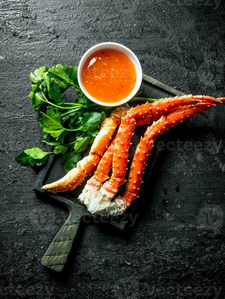 Crab on a cutting Board with parsley and sauce. photo