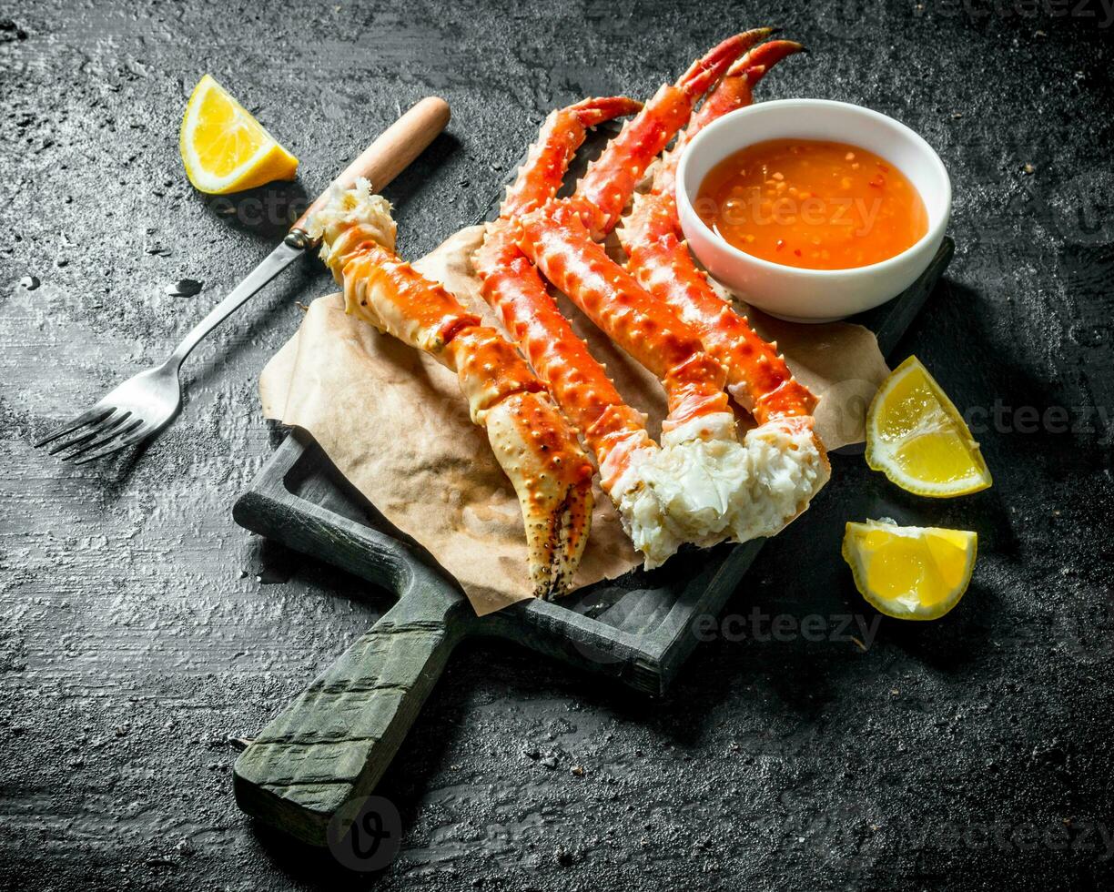 Crab on paper with lemon slices and sauce. photo