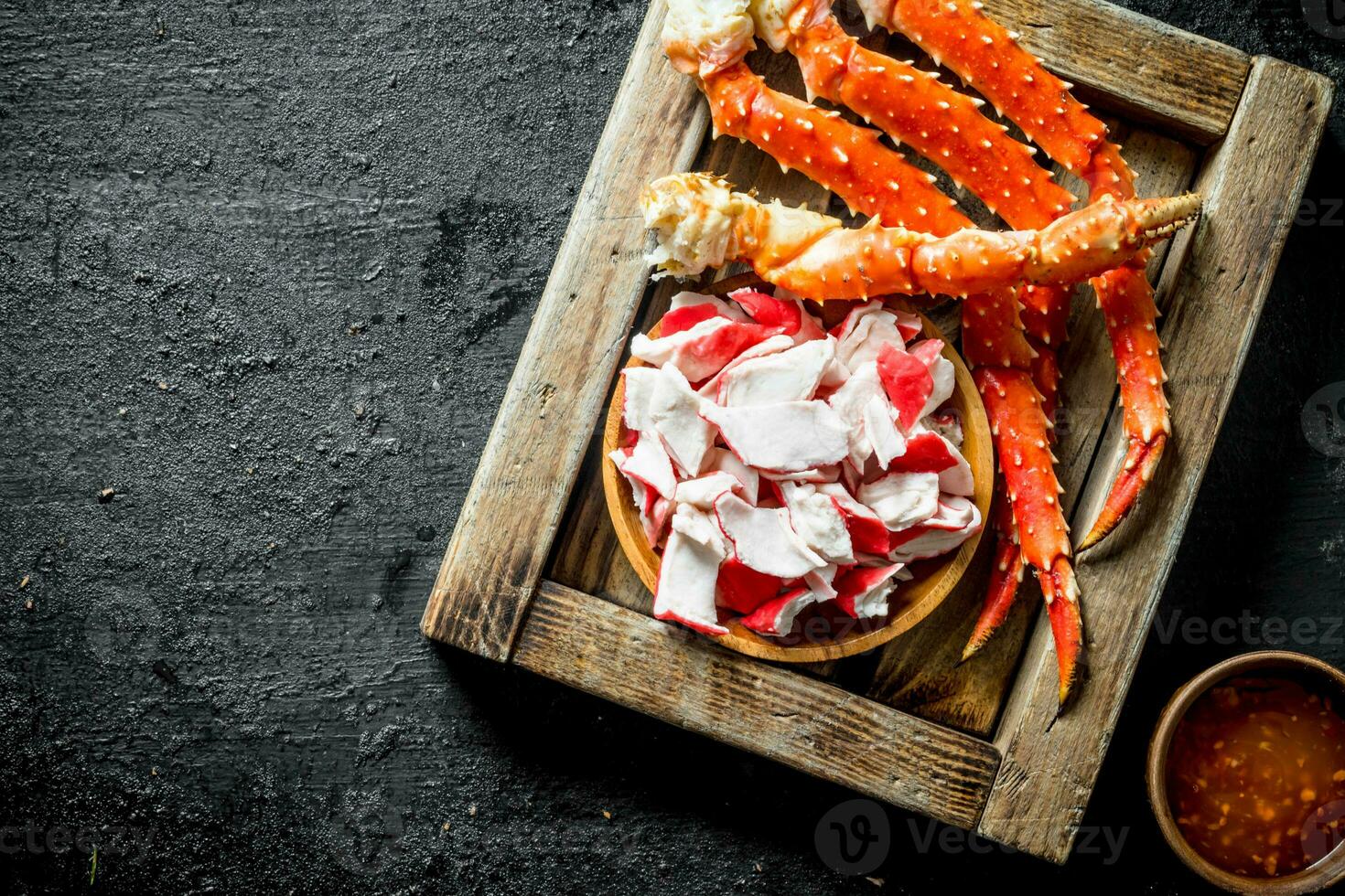 Crab meat and fresh crab on wooden tray with sauce. photo
