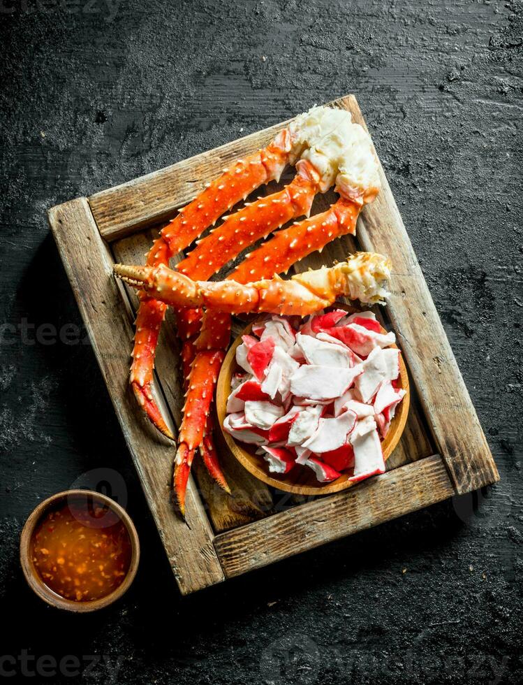 Crab meat and fresh crab on wooden tray with sauce. photo