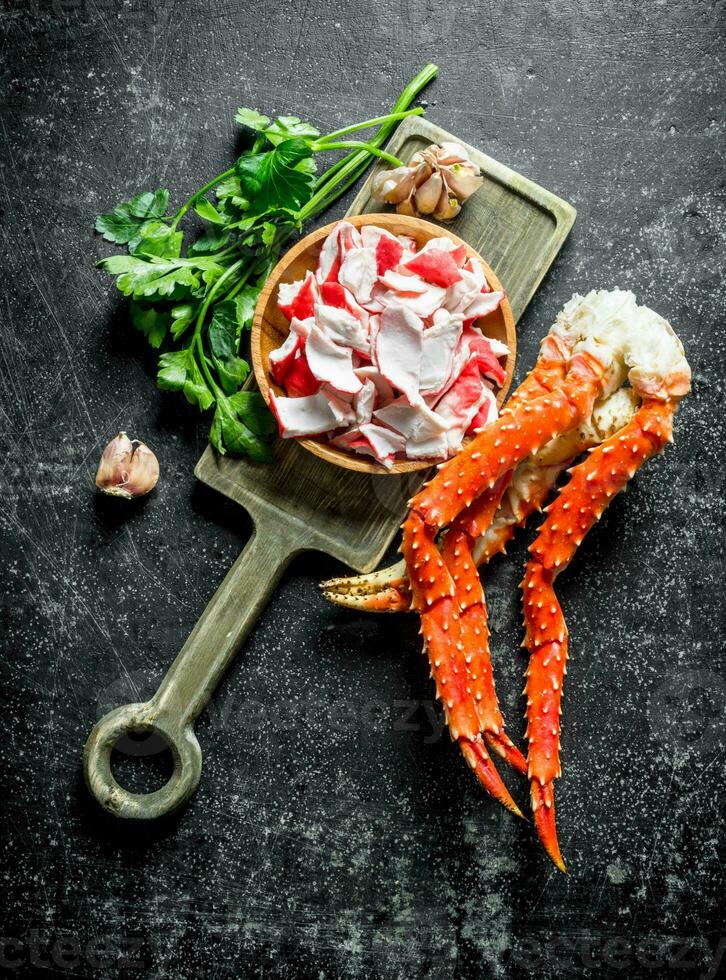 Crab meat and fresh crab on a cutting Board with greens and garlic. photo