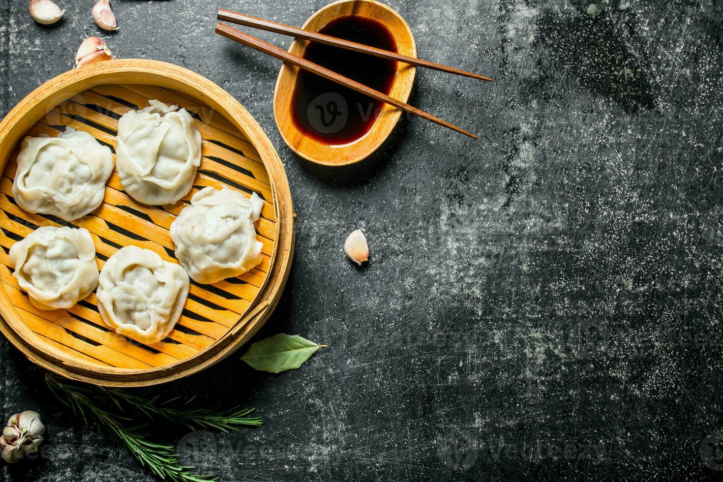 Traditional food. Manta dumplings in bamboo steamer with soy sauce. photo
