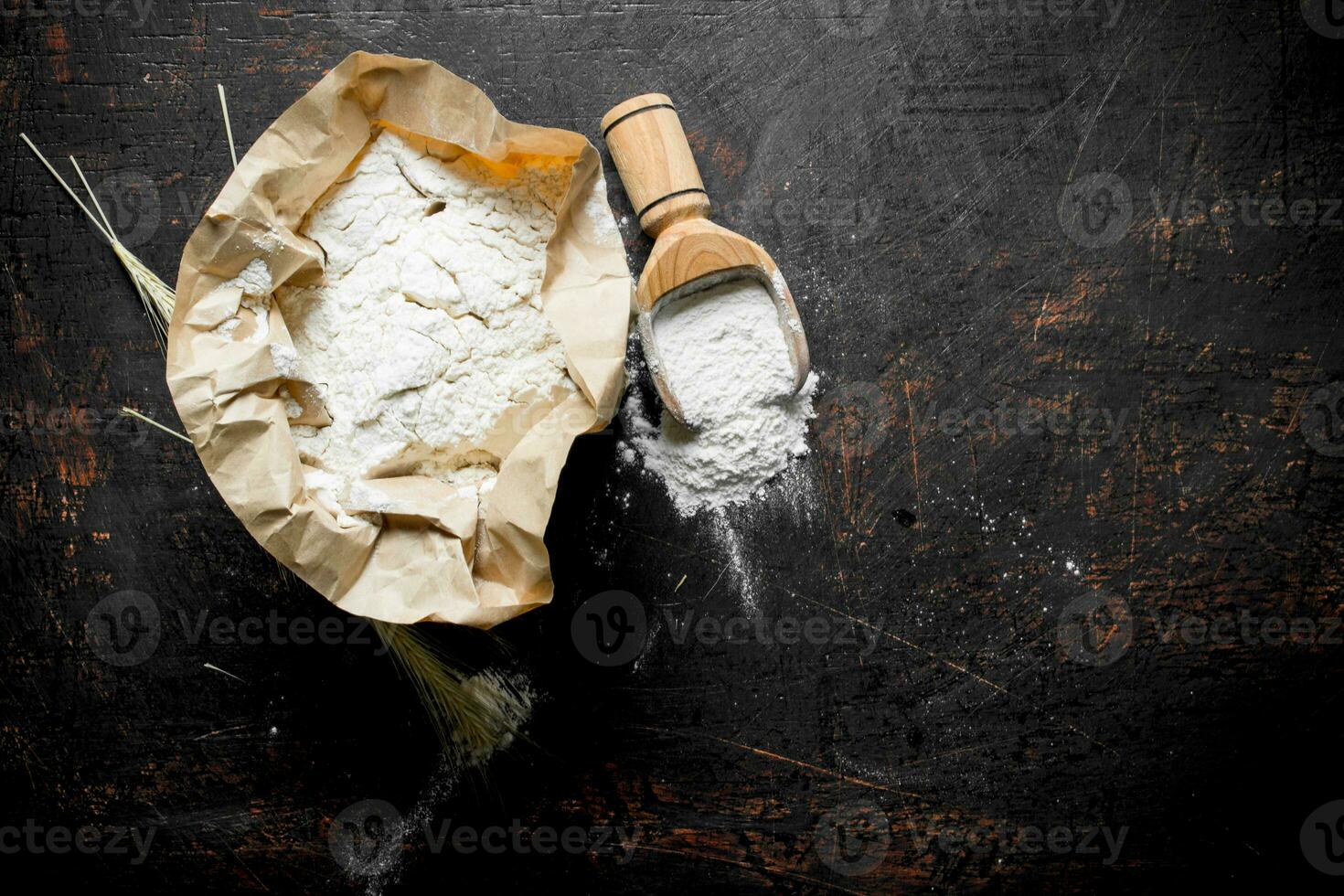Flour in paper with a scoop and spikelets. photo
