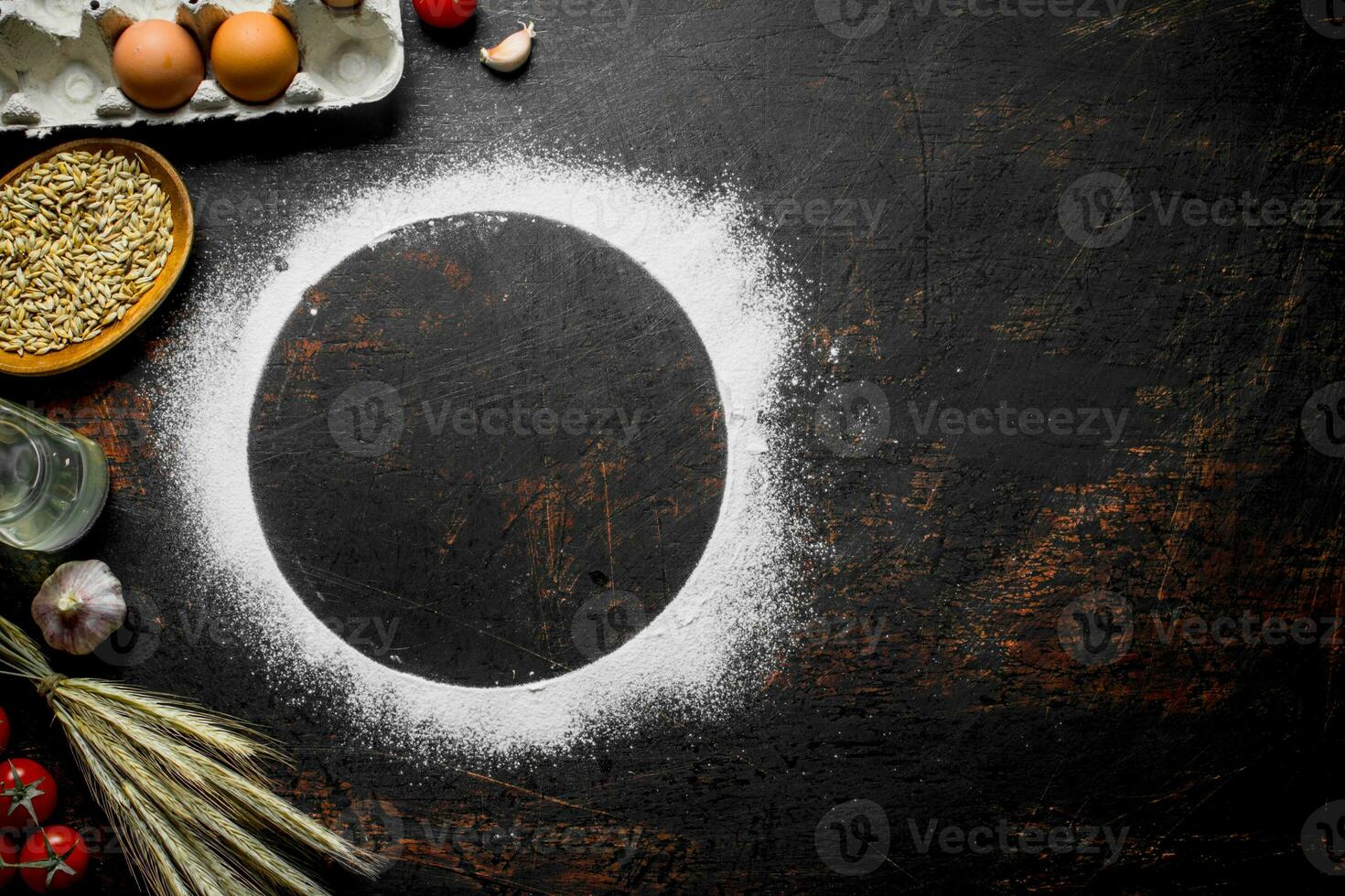 Round frame made of flour with spikelets, grain and eggs. photo