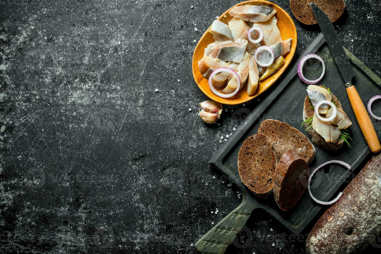 Fillet of salted herring on a piece of bread and onions. photo