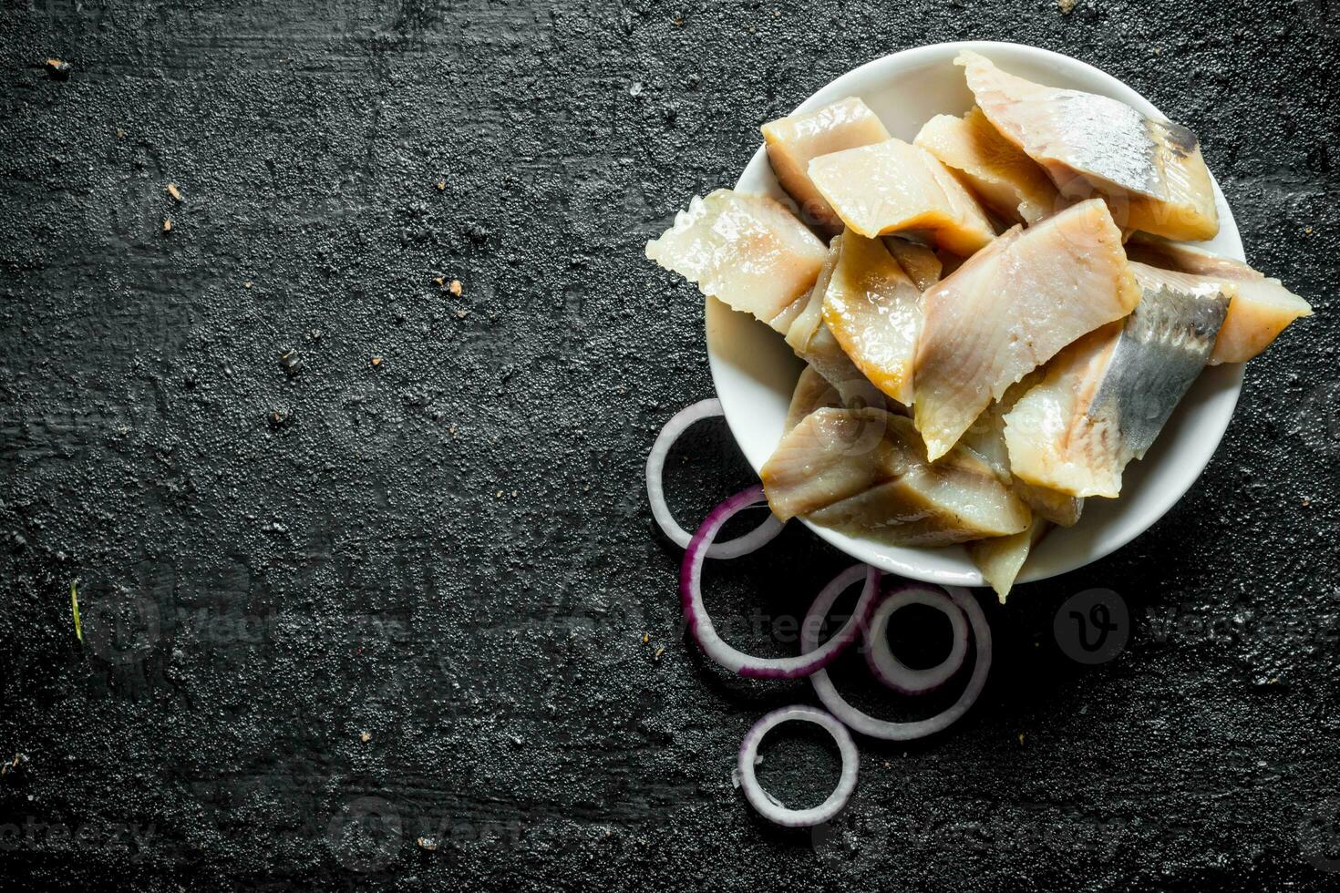 Sliced fillet of salted herring with onion rings. photo