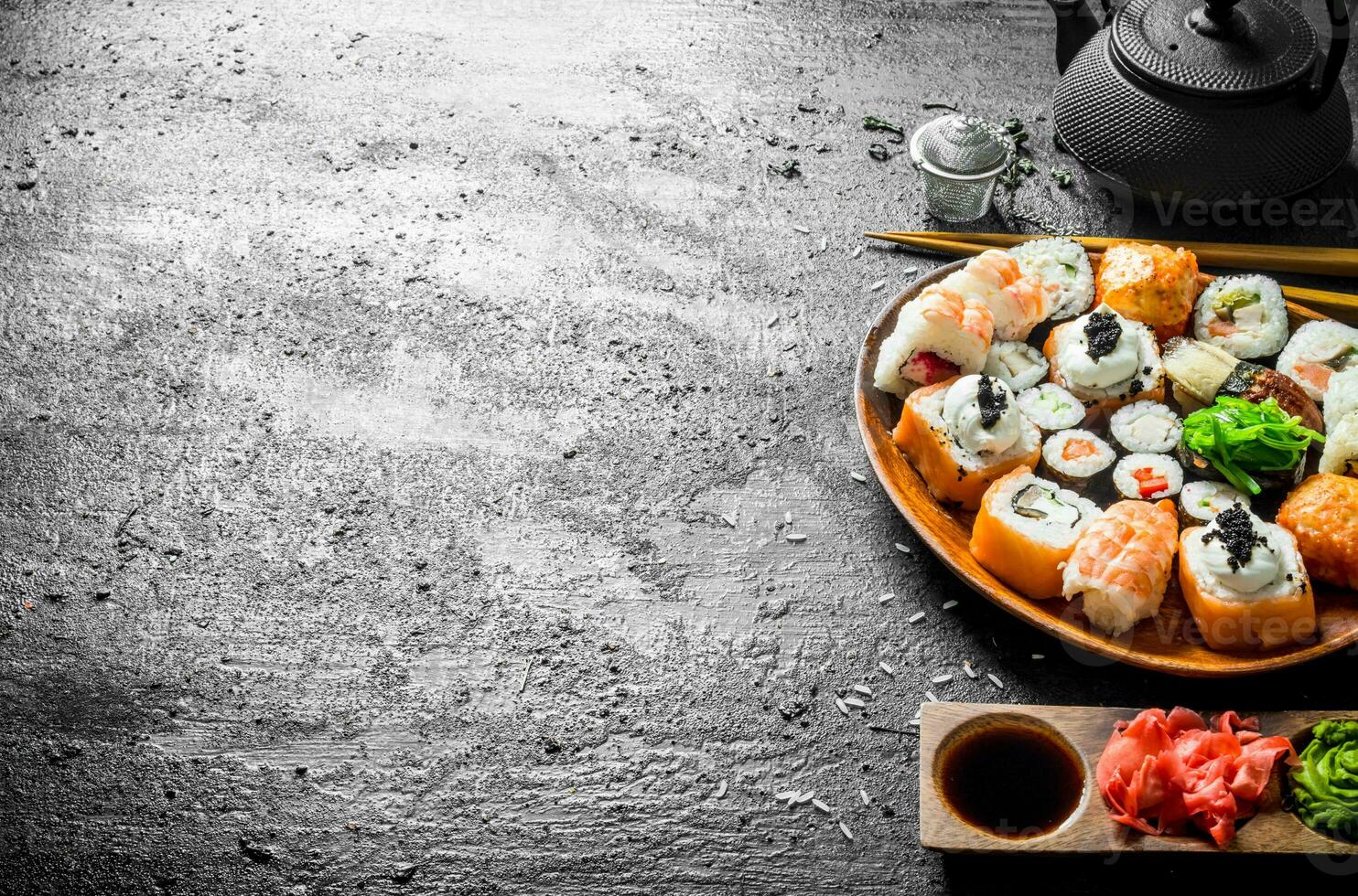 Delicious sushi rolls with shrimp, vegetables and salmon on a wooden plate. photo