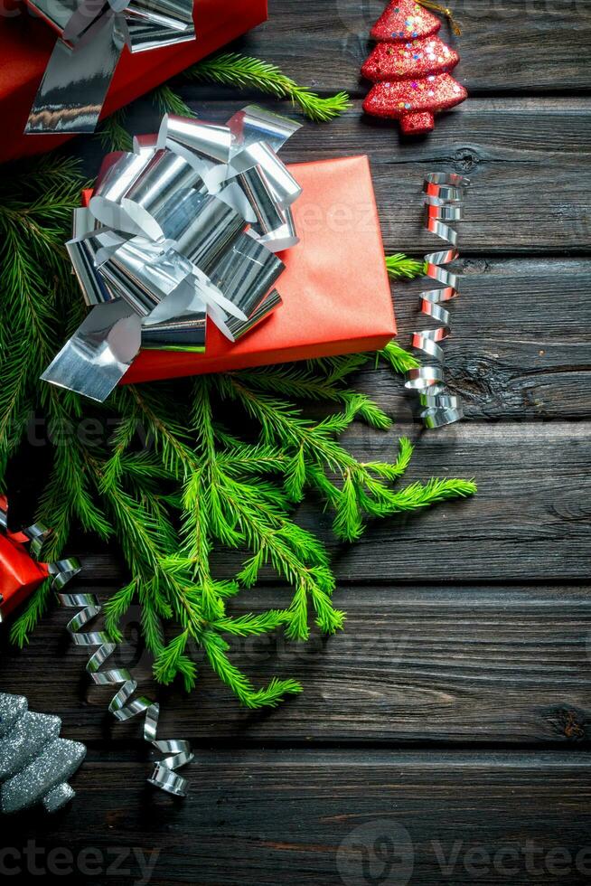 Red Christmas boxes with fir branches and streamers. photo