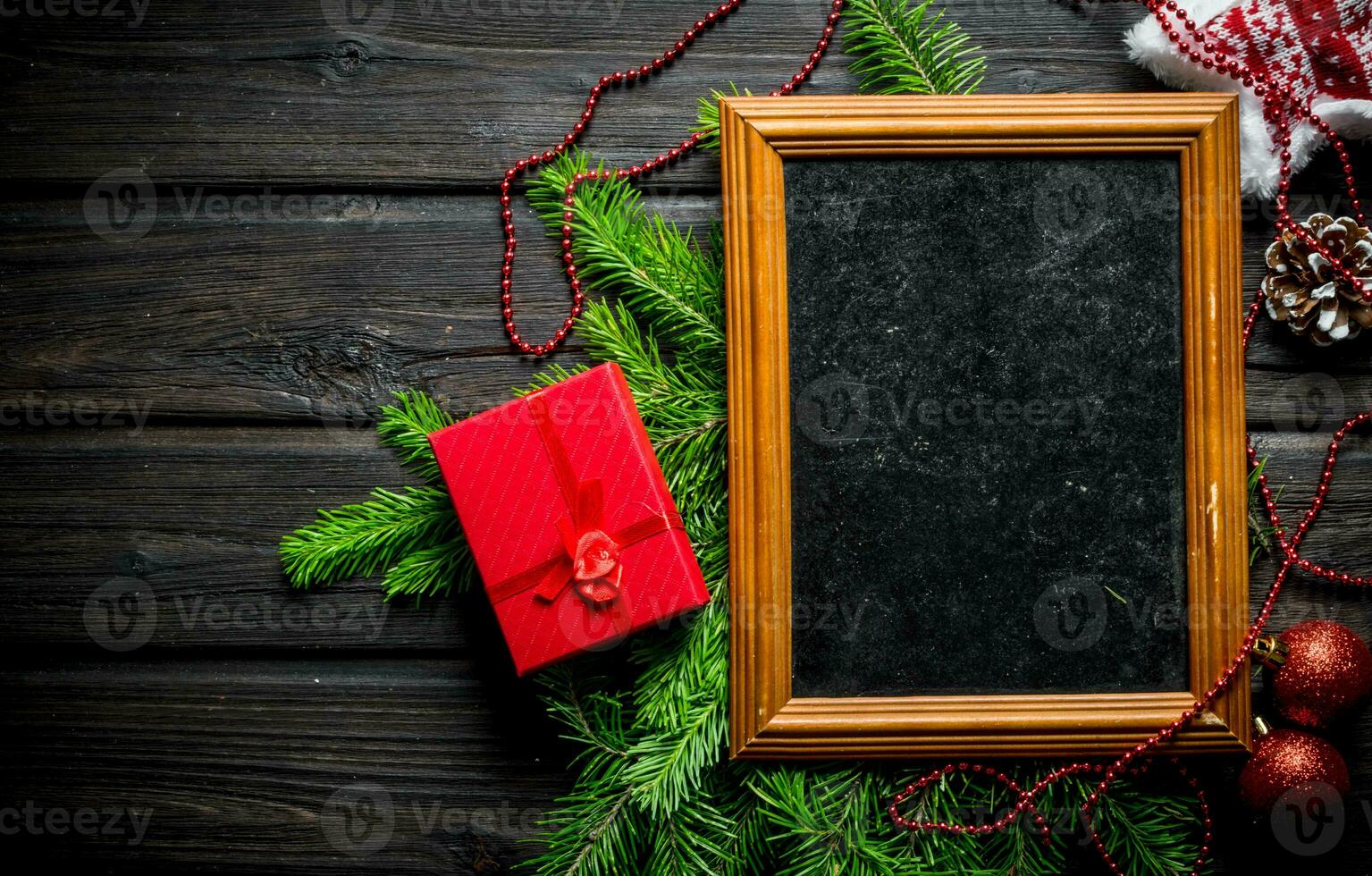 Photo frame with Christmas decorations and fir branches.