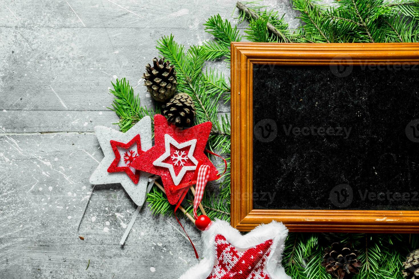 Photo frame with Christmas decorations, cones and fir branches.