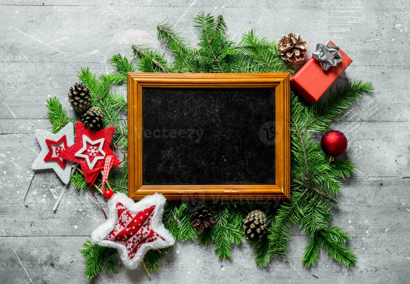 Photo frame with Christmas decorations, cones and fir branches.