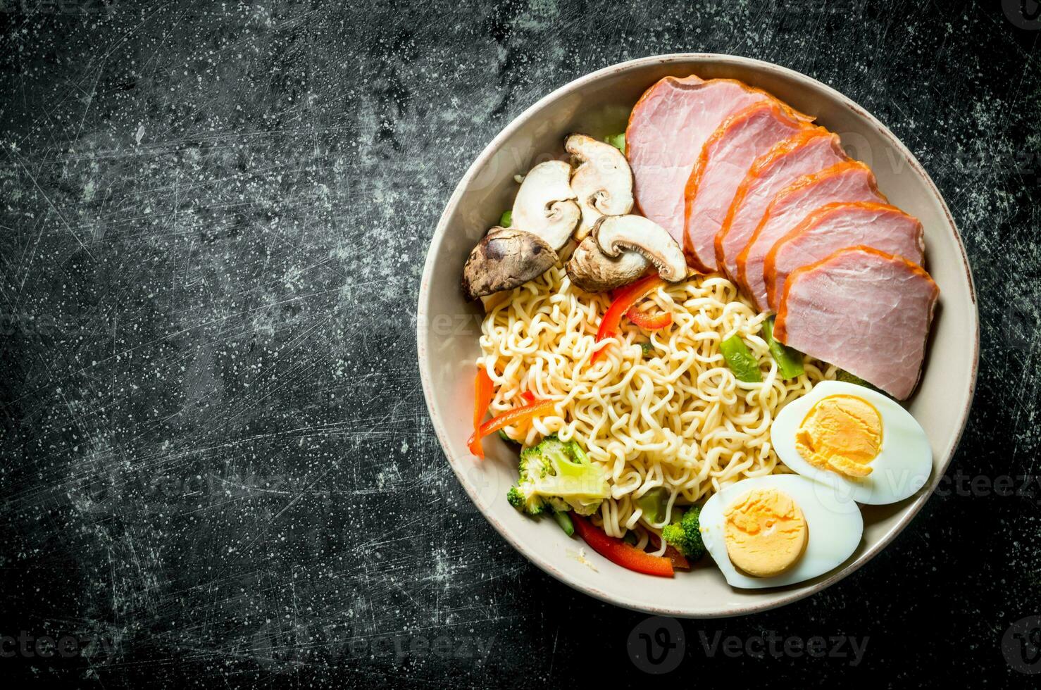 Instant noodles in bowl with broccoli, mushrooms, becon and egg. photo
