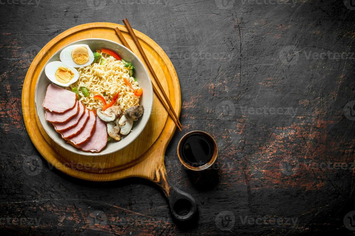 Instant noodles in bowl on cutting Board with becon, egg and mushrooms. photo