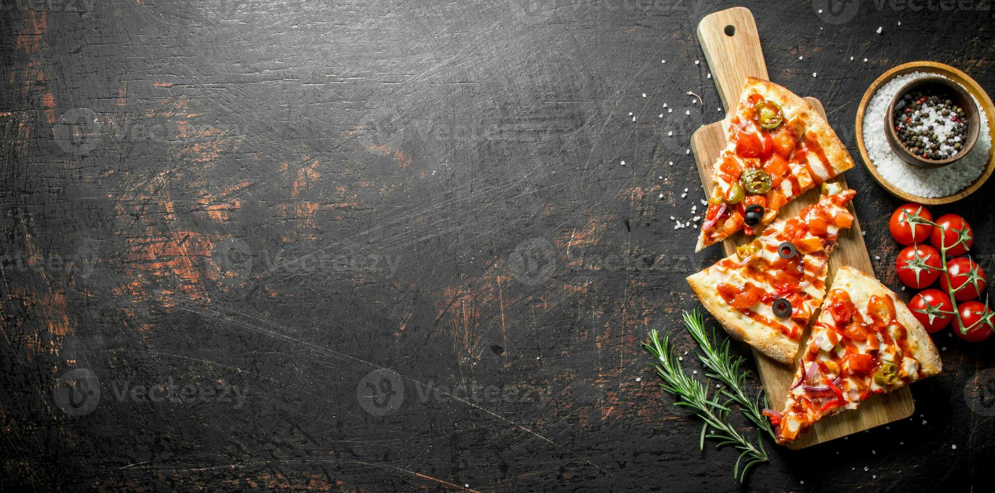 Slices of pizza with spices, tomatoes and rosemary. photo